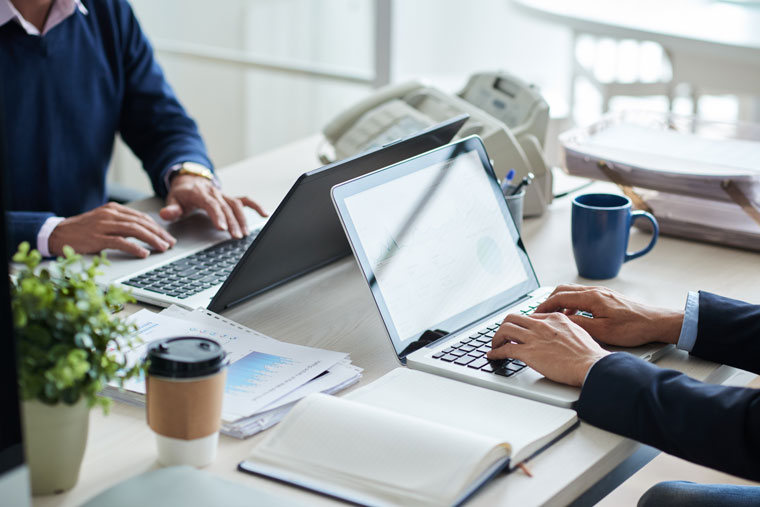 https://www.lasolascapital.com/wp-content/uploads/2021/03/side-view-cropped-unrecognizable-business-people-working-common-desk.jpg